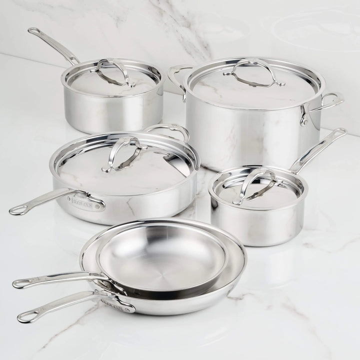 Set of stainless steel cookware on a marble surface