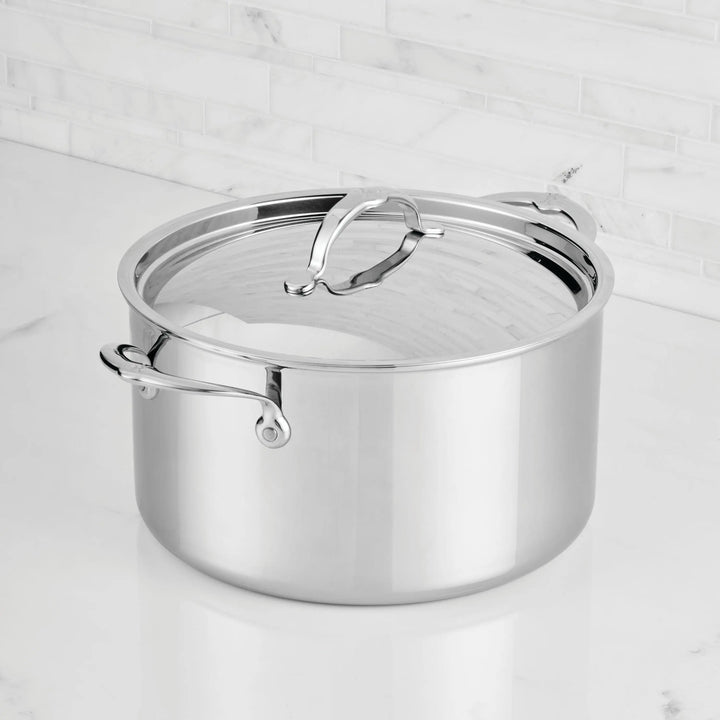 Stainless steel pot with lid on a marble surface