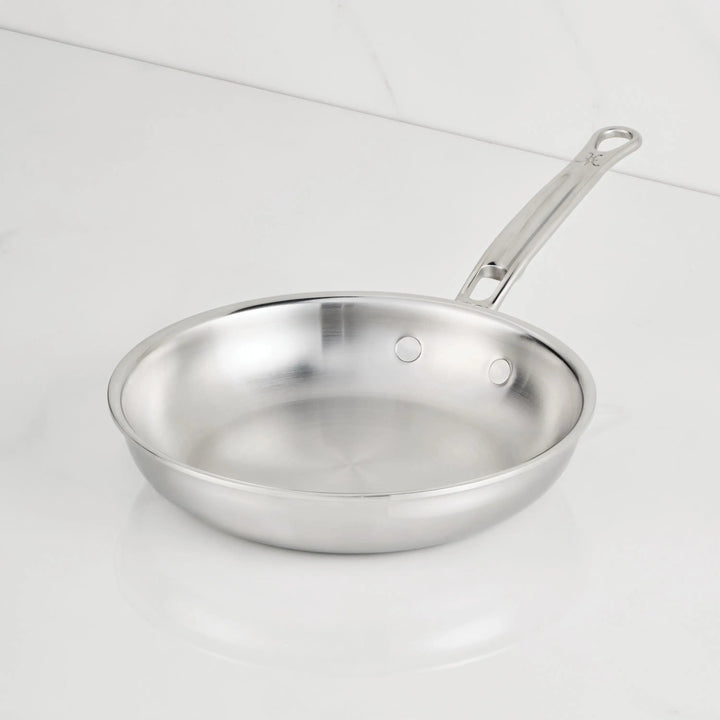 Stainless steel frying pan on a white background