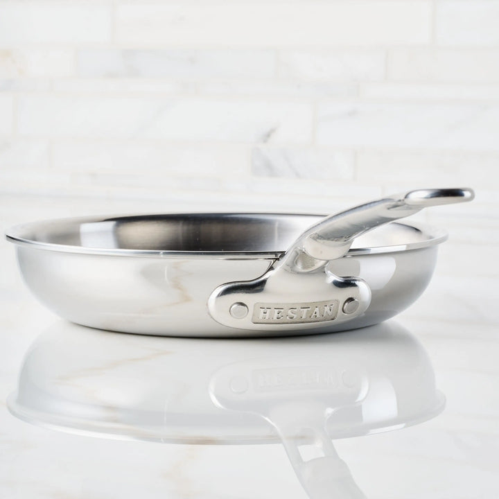 Stainless steel frying pan with handle on a white background