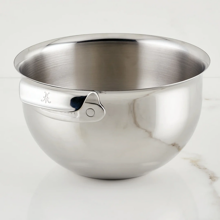 Stainless steel mixing bowl with a pouring spout on a white background