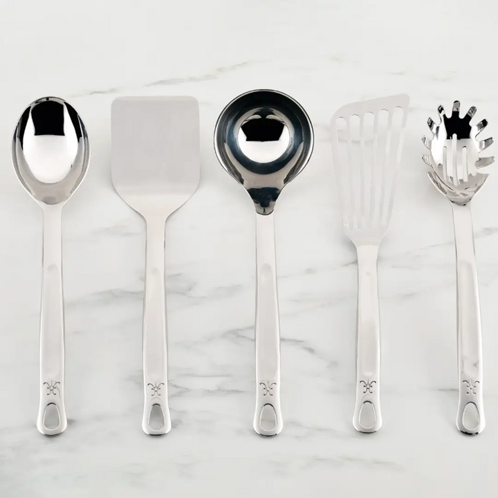 Set of silver kitchen utensils on a marble surface